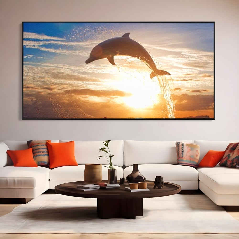 Tablou canvas cu delfin care sare la apus, in rama de aluminiu negru, pe perete intr-un living